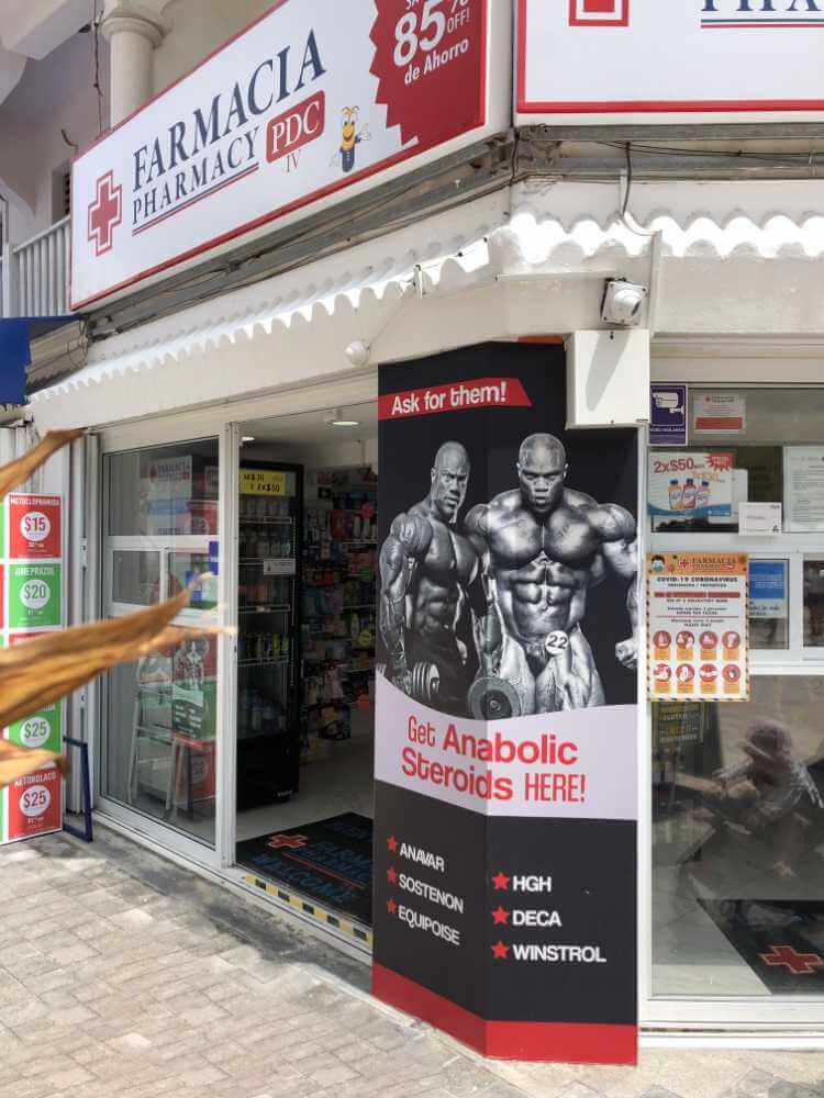 Apotheke mit einem großen Werbebanner, auf dem 2 sehr muskulöse Bodybuilder zu sehen sind. Darunter wird Anabolika angeboten.